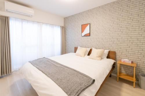 a bed in a room with a brick wall at 住舎桜ノ宮 in Osaka