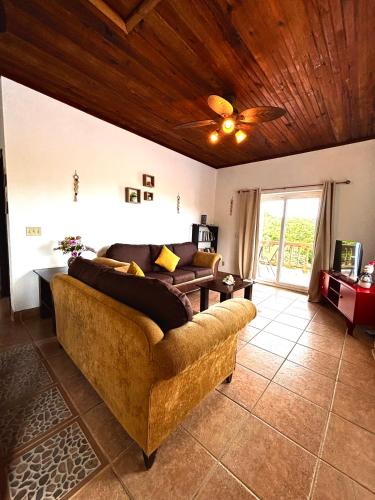 a living room with a couch and a ceiling fan at Sunset Views Apartment, West End in West End