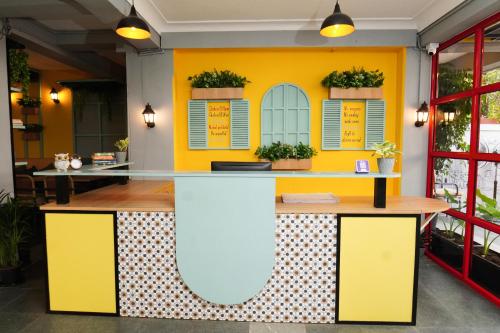 a restaurant with yellow walls and a counter with plants at Vib O Stay in Pune