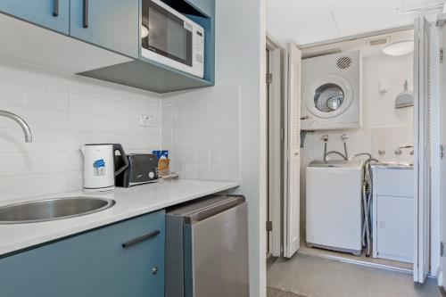 a small kitchen with a sink and a refrigerator at Serain Chatswood Central in Sydney