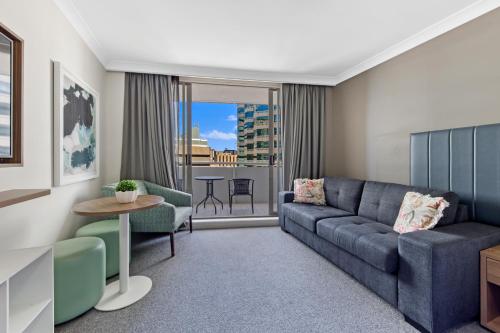 a living room with a couch and a table at Serain Chatswood Central in Sydney