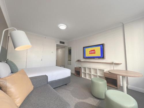 a hotel room with a bed and a table at Serain Chatswood Central in Sydney