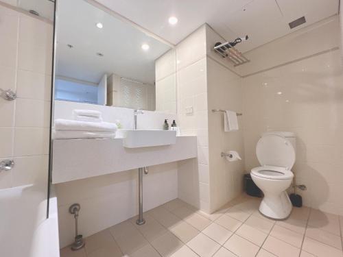 a bathroom with a toilet and a sink and a shower at Serain Chatswood Central in Sydney