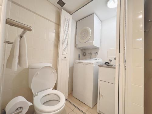 a white bathroom with a toilet and a sink at Serain Chatswood Central in Sydney