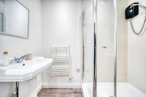 カーディフにあるStunning 2 Bed by the City Centre & Bute Parkの洗面台とシャワー付きの白いバスルーム