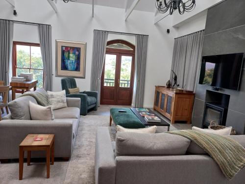 a living room with two couches and a tv at De Zalze Lodge in Stellenbosch