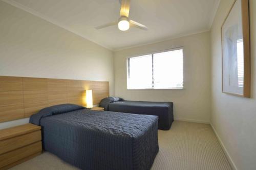 a bedroom with a bed and a ceiling fan at Ivory Palms Resort Noosa in Noosaville