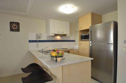 a kitchen with a stainless steel refrigerator and a bowl of fruit at Ivory Palms Resort Noosa in Noosaville