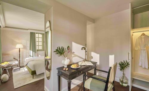 a bedroom with a desk and a bed and a mirror at President Maison Signature By M Village in Ho Chi Minh City