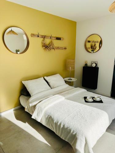 - une chambre avec un grand lit blanc et deux miroirs dans l'établissement Maison ensoleillée climatisée avec terrasse et parking, à Saint-Victor-la-Coste