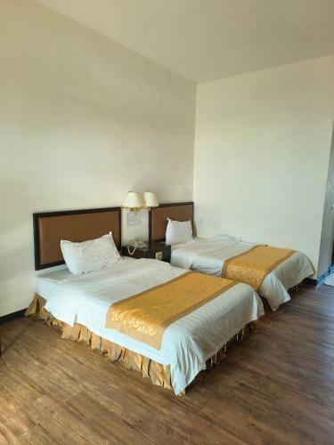 two beds in a hotel room with two bedsvisor at 海天酒店 in Nangan