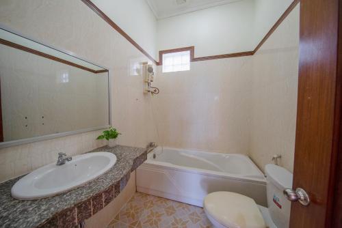 a bathroom with a sink and a tub and a toilet at Twin Villa Siem Reap in Siem Reap