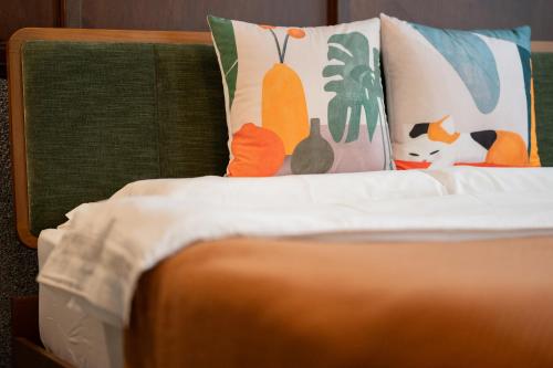 a bed with colorful pillows on top of it at 安樓文旅 Enzo House in Keelung