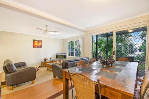 a living room with a table and a dining room at Ivory Palms Resort Noosa in Noosaville