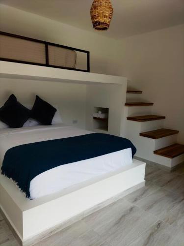 a bedroom with a bed with a blue blanket at Río Celeste Poshtel Tayrona - Zaino in Calabazo