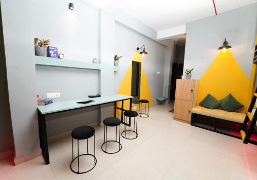 a room with a desk and stools in it at Vib O Stay in Pune