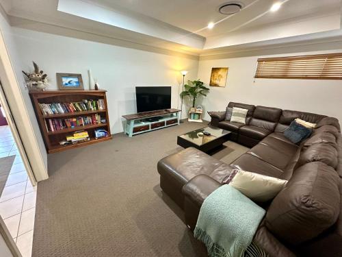 a living room with a couch and a television at Hideaway on Peel in Busselton