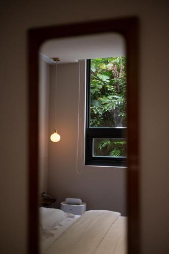 a mirror view of a bedroom with a window at 安樓文旅 Enzo House in Keelung