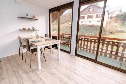 a dining room with a table and chairs and a balcony at L'Horizon des Randonneurs - Duplex avec Balcon in Les Hôpitaux-Neufs