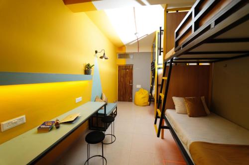 a room with a bed and a desk and bunk beds at Vib O Stay in Pune