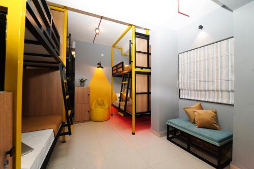 a dorm room with bunk beds and a yellow wall at Vib O Stay in Pune