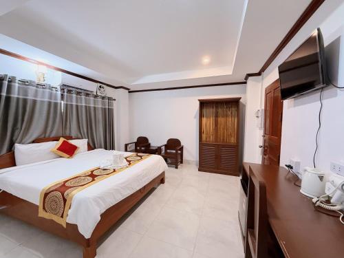 a bedroom with a bed and a flat screen tv at Vangvieng Sisavang Mountain View Hotel in Vang Vieng
