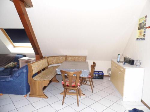 une cuisine avec une table et des chaises dans une pièce dans l'établissement Gîtelindenberg 1 etage, à Dambach