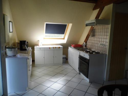 Il comprend une petite cuisine avec une cuisinière et une fenêtre. dans l'établissement Gîtelindenberg 1 etage, à Dambach