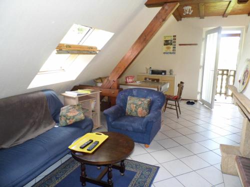 un salon avec un canapé bleu et une table dans l'établissement Gîtelindenberg 1 etage, à Dambach