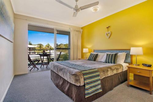 a bedroom with a large bed and a balcony at Ivory Palms Resort Noosa in Noosaville