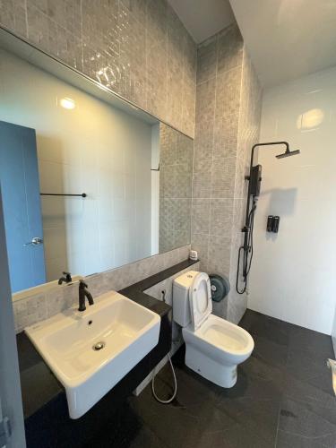 a bathroom with a sink and a toilet and a mirror at Bluda Poolvilla B in Hat Yai