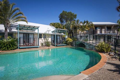 a large swimming pool in front of a house at Ivory Palms Resort Noosa in Noosaville