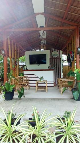 a patio with benches and a flat screen tv at Kerusso Haven in Puerto Princesa City
