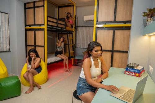 a group of women in a room with bunk beds at Vib O Stay in Pune