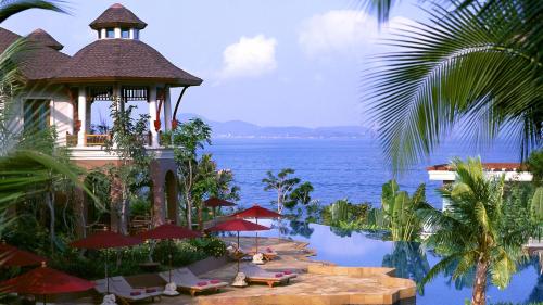 a resort with a pool with umbrellas and the ocean at InterContinental Pattaya Resort by IHG in Pattaya South