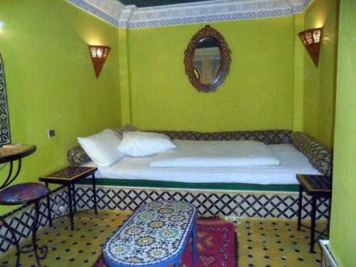 a bedroom with a bed in a green room at Dar Ayour appartements in Essaouira