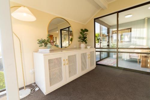 a home hallway with a mirror and a table at River City Views With Spa Pool, BBQ & Sky TV in Whanganui