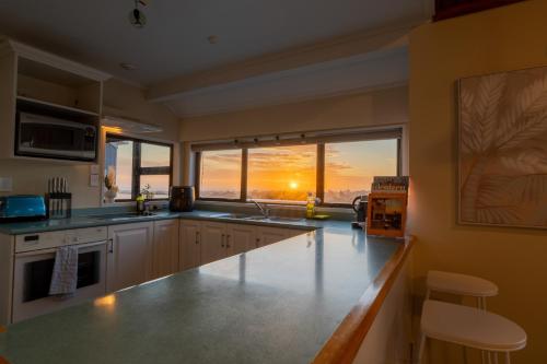 a kitchen with a counter and a large window at River City Views With Spa Pool, BBQ & Sky TV in Whanganui