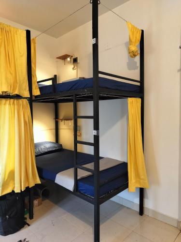 a room with three bunk beds in a room at The Hostel Stories, Varkala - Helipad Road in Varkala