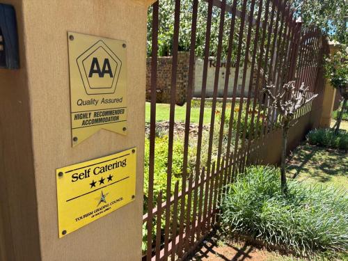 a gate with a sign that says self gardening at Ruresta Guesthouse in Bloemfontein