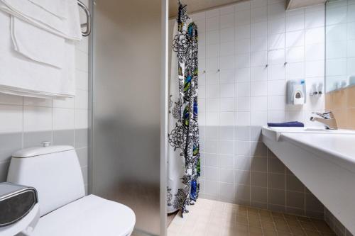 a bathroom with a toilet and a sink at Hotelli Puustelli Lieksa in Lieksa