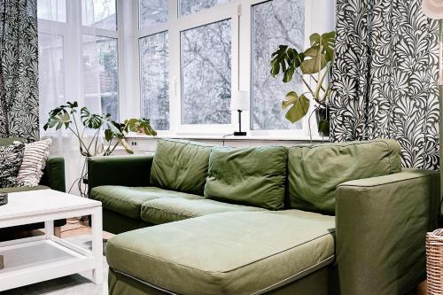 a living room with a green couch and windows at Dohna, App 117 in Pirna