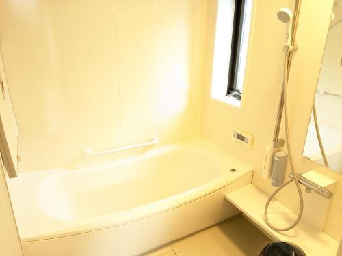 a white bath tub in a bathroom with a window at 有馬ヴィラ木の家 1日1組限定 貸し切りのリバーサイドヴィラ in Kobe