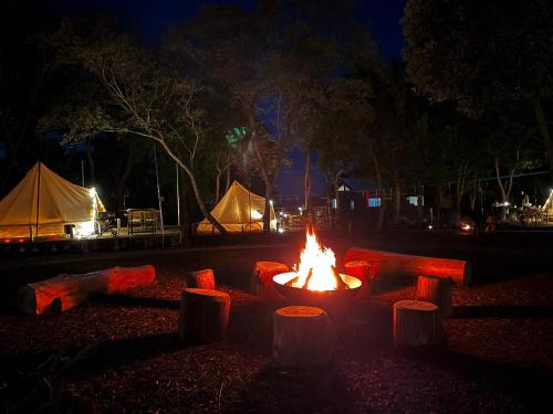 a fire pit at night with tents in the background at COUSCOUS Glamping Manazuru in Manazuru