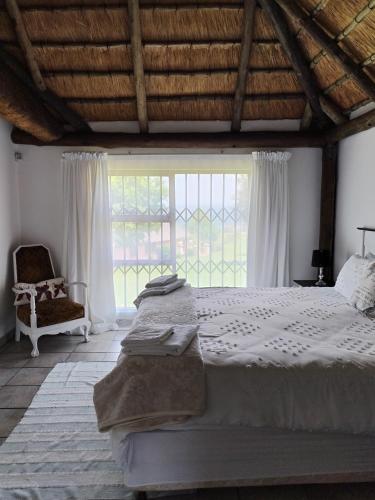 a bedroom with a large bed and a window at lrish Mist Estate in Howick