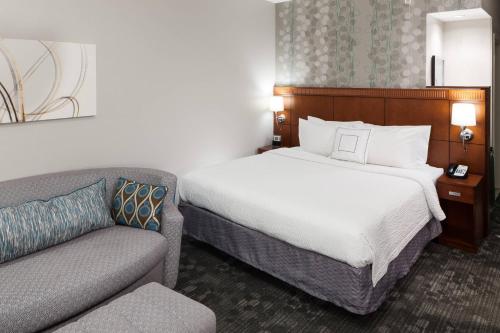 a hotel room with a bed and a couch at Courtyard by Marriott Miami at Dolphin Mall in Miami