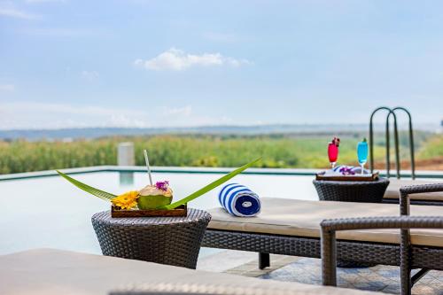 a table with a drink on it next to a pool at Sterling Palavelli Godavari in Rāzole