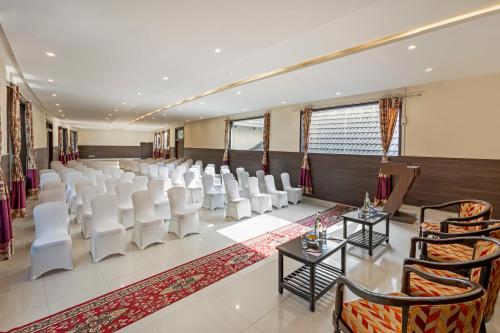 a room with rows of white chairs and tables at Sterling Palavelli Godavari in Rāzole