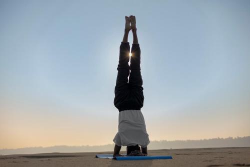 a person doing a handstand in the desert at Sterling Palavelli Godavari in Rāzole
