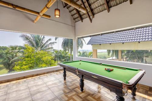 a pool table in a room with large windows at Sterling Palavelli Godavari in Rāzole